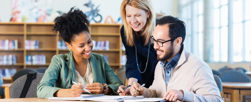 header image three adults studying in library